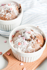 Valentine's day chocolate mug cake or brownie with powdered sugar and sweet heart shaped sprinkles, white table background, copy space top view