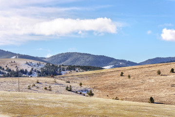 rural mountain landscape of fields with trees vegetation and blue sky
