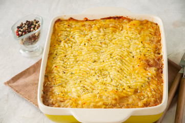 Shepherds pie -  Irish traditional food. Served in a ceramic dish on a white stone background.