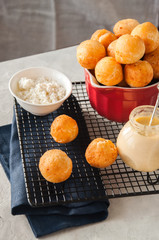 Small cottage cheese doughnuts (castgnole) served on a wire rack. White stone background.