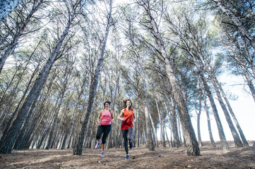 Fototapeta premium two beautiful women running through the forest