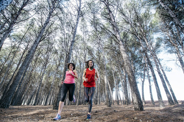 Fototapeta premium two beautiful women running through the forest