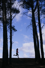 silhouette of two beautiful women running through the forest.