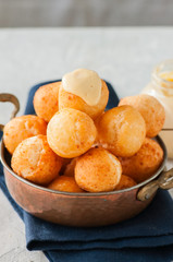 Small cottage cheese doughnuts (castgnole) in a bowl. White stone background.