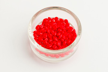 dish of small red seed beads used to create jewelry