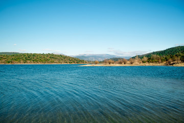 See mit Panoramablick auf Bergkette unter blauem Himmel