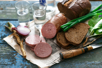 Sliced sausage with rye bread, onion and vodka