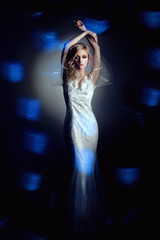 Fototapeta na wymiar Bride model in studio on blue and black background
