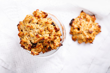 Healthy oatmeal cookies with raisins on white table.