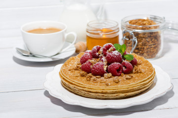 traditional thin pancakes with fresh raspberries for breakfast on wooden table
