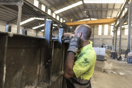 Man adjusting concrete structure in construction factory. Adjusting the mold to create a piece of cement