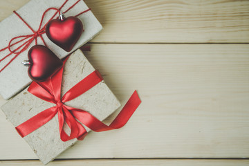 valentine day background. Top view of gift boxes and two red heart on the wooden table background vintage style. have a copy space for text.