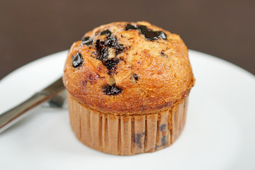 Delicious fresh homemade bakery. chocolate chip muffins serve on white plate and knife.