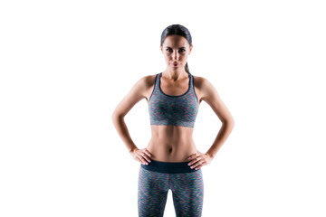 Front view portrait of serious concentrated beautiful concentrated strict serious fitness trainer wearing tight sportive outfit, she puts her hands on hips, isolated on white background