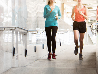 Two young girl runners running in the city exercise in the morning.