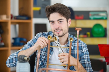 young industrial plumber welding fitting coopers