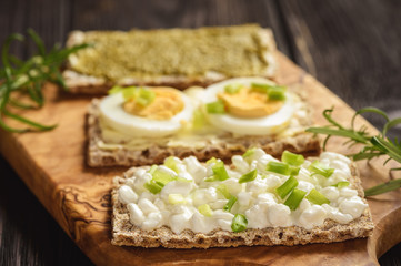 Rye crisp bread sandwiches with eggs, pesto and cottage cheese.