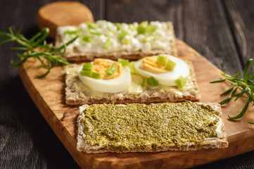 Rye crisp bread sandwiches with eggs, pesto and cottage cheese.