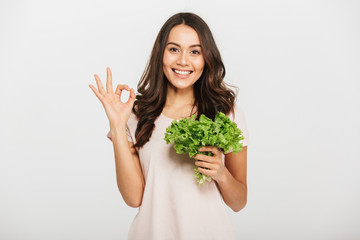 Portrait of a smiling young asian woman holding lettuce