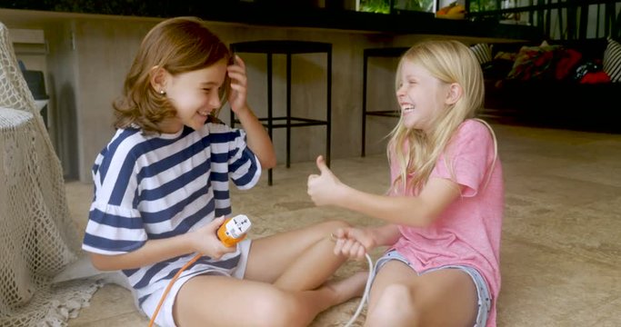 Two adorable young girls disconnect a power cord and give the thumbs up