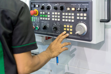 Mechanical technician operating program on control panel of high precision CNC machining center, machining die metal mold process