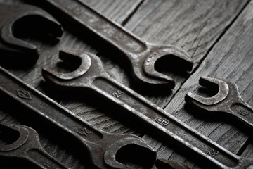 Dirty set of hand tools on a wooden background. Old rusty tools Sales tools for assembly workers.  Old shop Old working. Vintage working tools (drill, saw, ruler and others) on wooden background