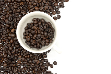 top view closeup of a coffee cup filled with roasted coffee beans o of roasted coffee beans isolated on white background .