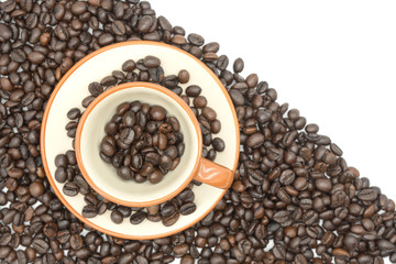 top view closeup of a coffee cup filled with roasted coffee beans o of roasted coffee beans isolated on white background .