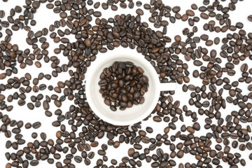 top view closeup of a coffee cup filled with roasted coffee beans o of roasted coffee beans isolated on white background .