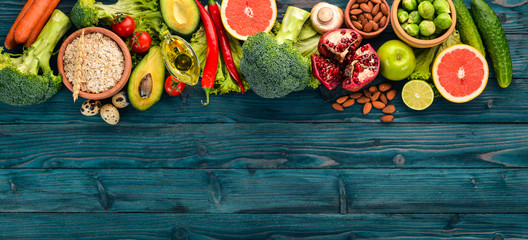 Healthy food background. Concept of Healthy Food, Fresh Vegetables, Nuts and Fruits. On a wooden background. Top view. Copy space.