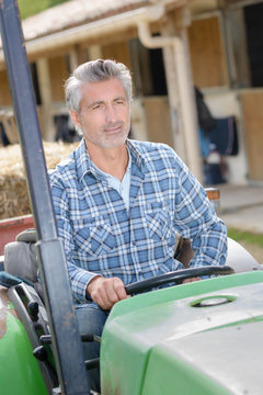 cattle farmer driving a garden tractor