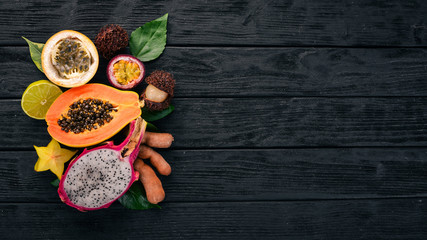 Papaya, Dragon Fruit, Cactus Fruit. Fresh Tropical Fruits. On a wooden background. Top view. Copy space.