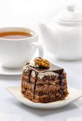 cake on background of cup with tea and teapot