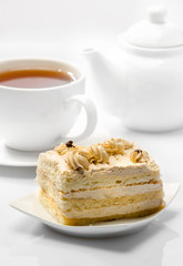 cake on background of cup with tea and teapot