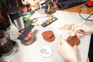 Close up of hands tanner performs work on table with tools