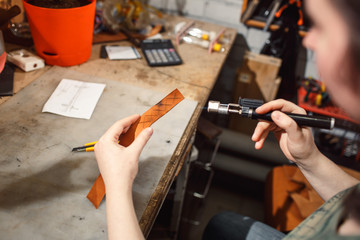 Close up of hands tanner performs work on table with tools