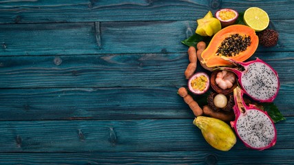 Papaya, Dragon Fruit, Cactus Fruit. Fresh Tropical Fruits. On a wooden background. Top view. Copy space.
