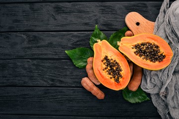 Papaya and Tamarind. Fresh Tropical Fruits. On a wooden background. Top view. Copy space.