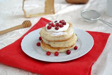 Berry pancakes with sour cream sauce and powdered sugar