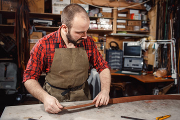 Working process in the leather workshop. Tanner in old tannery.