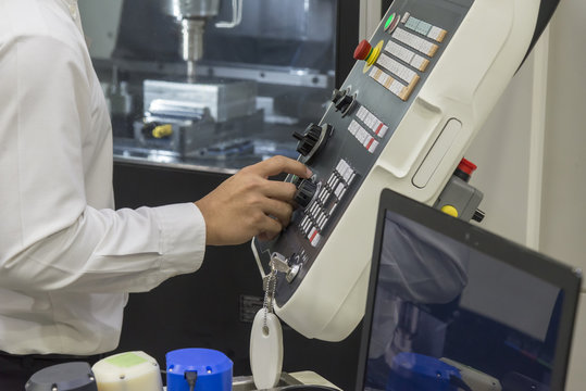 The machine operator press the control panel of CNC machine .High precision CNC machining operation concept.