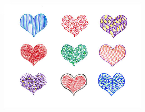 Hand drawn hearts of various colors of ink on paper.