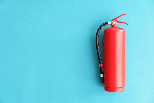 Fire extinguisher on the blue wall background.