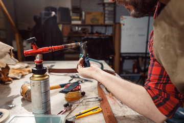 Close up of hands tanner performs work on table with tools