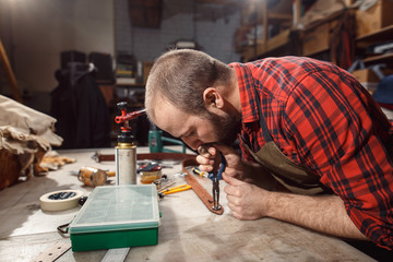 Working process in the leather workshop. Tanner in old tannery.