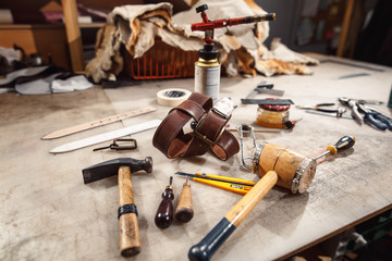 Close up of hands tanner performs work on table with tools