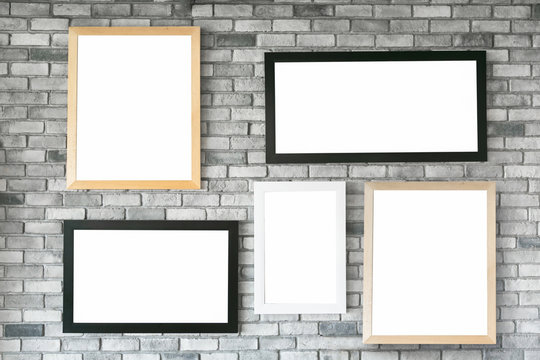 Different size and style empty photo frames on white concrete wall. with clipping path