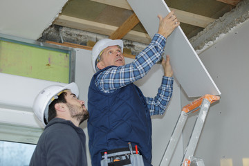 builder installing the rest of the drywall on the ceiling