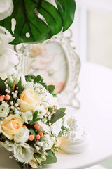 gold wedding rings on bride's bouquet of white and delicate beige roses, wedding decor