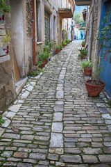 narrow street with old traditional houses and cobblestone road in old village